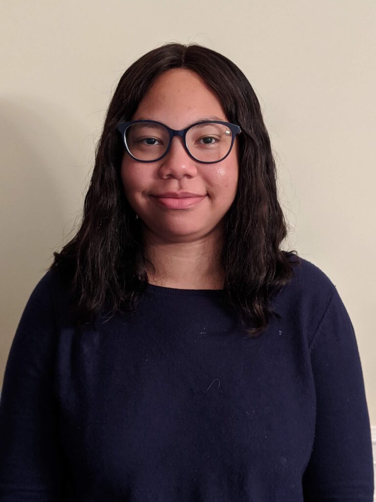 A woman with glasses is smiling for the camera.