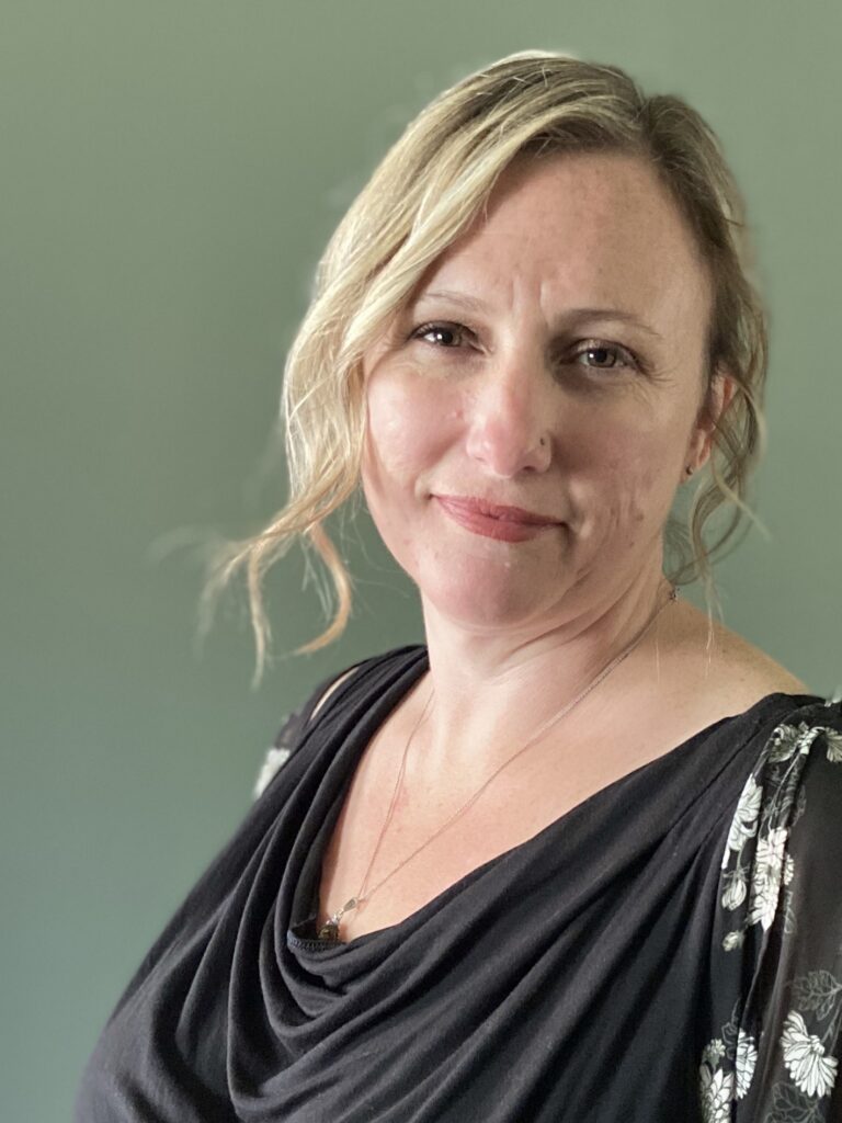 A woman with blonde hair wearing black and white.